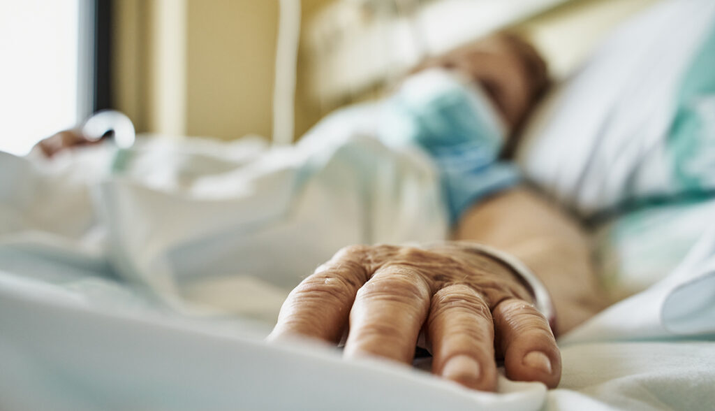 Senior woman wearing face mask lying on hospital bed